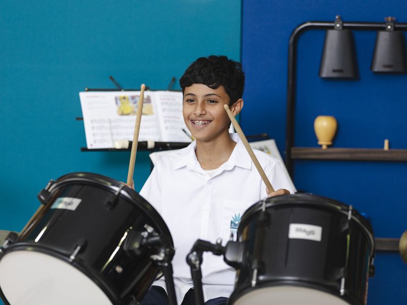 A pupil at the drum kit in the music room