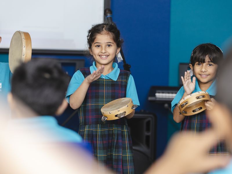 Pupils playing tambourines in a music lesson