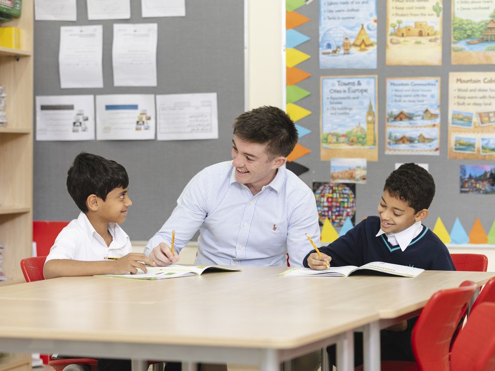 A teacher working with pupils in a primary classroom